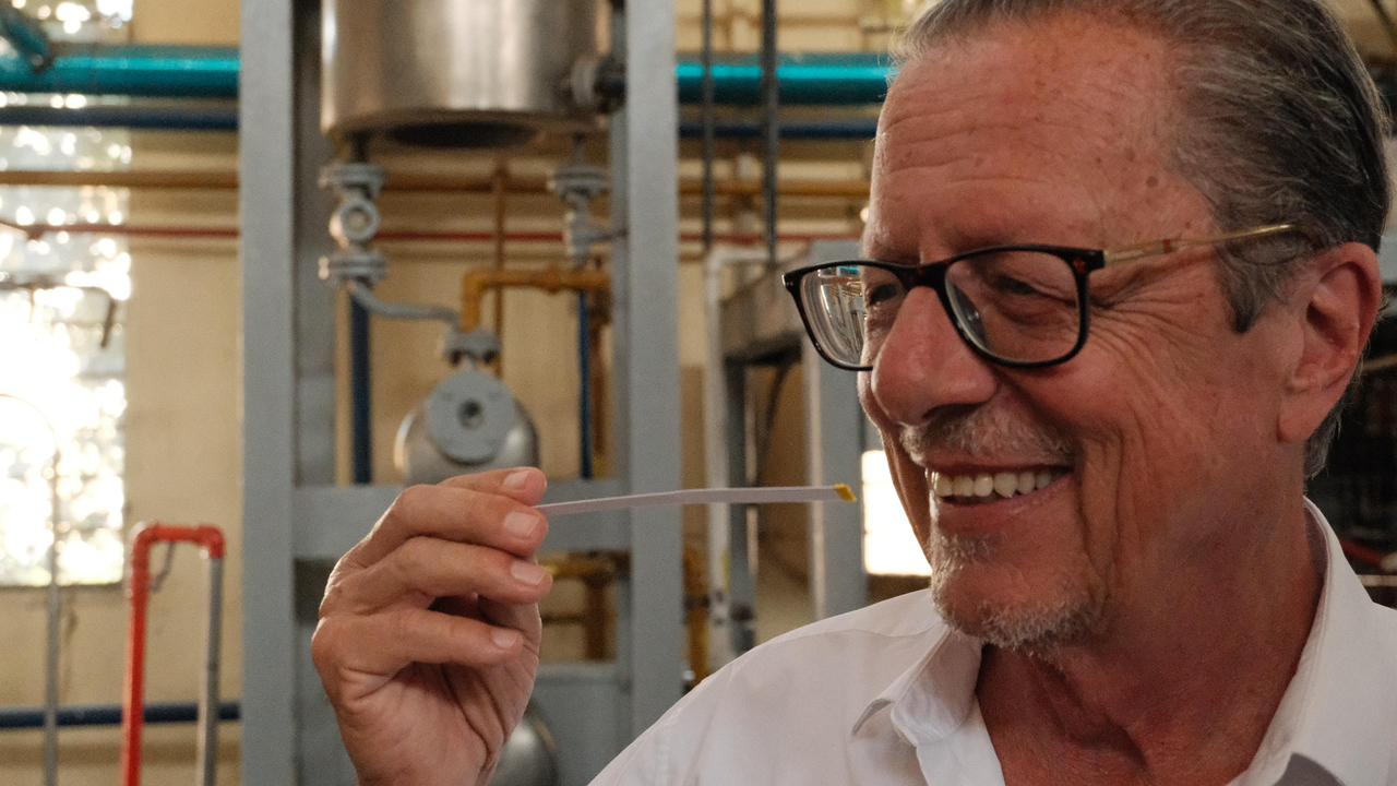 Nicolas de Barry sorrindo enquanto cheira uma tira de papel em um laboratório de perfumaria